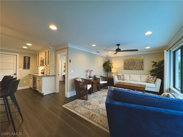 living room with dark wood-type flooring, ceiling fan, and crown molding