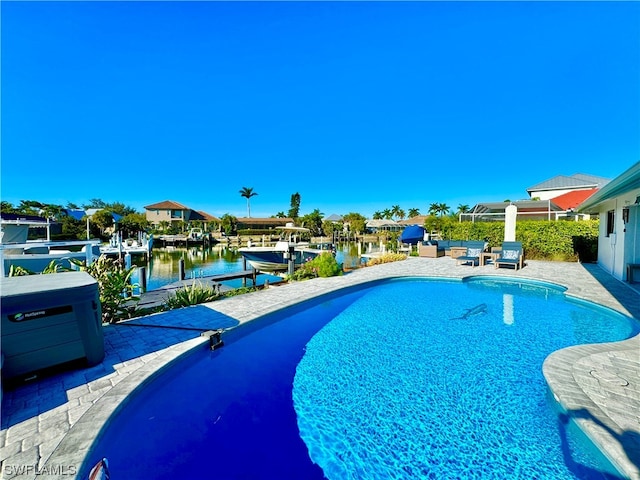 view of swimming pool with a patio, a water view, and a dock