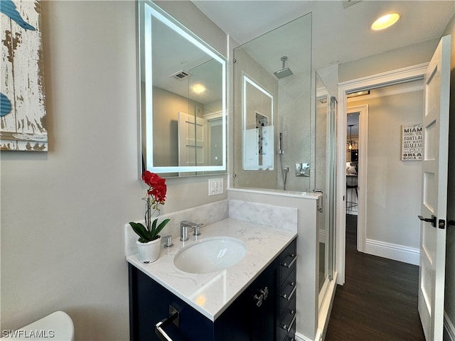 bathroom with vanity, wood-type flooring, toilet, and a shower