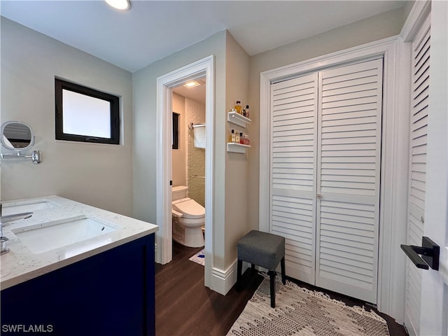 bathroom with wood-type flooring, toilet, and vanity