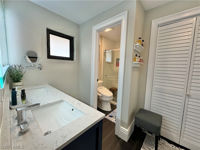 bathroom featuring vanity, hardwood / wood-style floors, toilet, and walk in shower