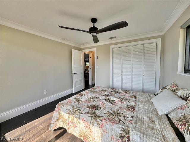 bedroom with ornamental molding, a closet, hardwood / wood-style flooring, and ceiling fan