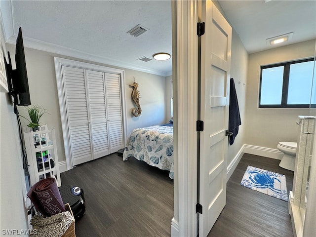 bedroom featuring ornamental molding, dark wood-type flooring, and a textured ceiling