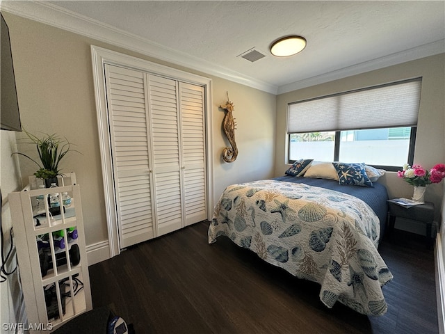 bedroom with crown molding, dark hardwood / wood-style floors, a closet, and a textured ceiling