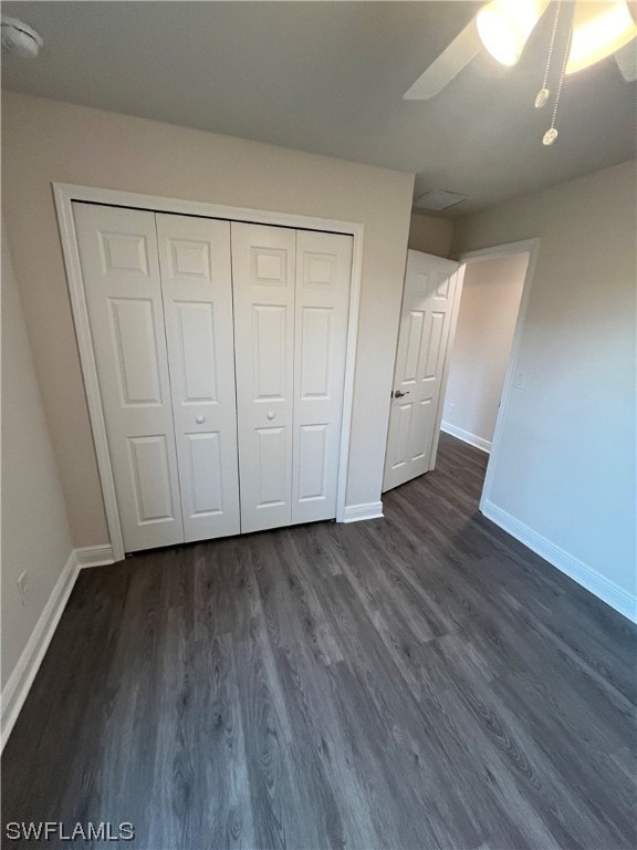 unfurnished bedroom featuring ceiling fan, dark wood-type flooring, and a closet