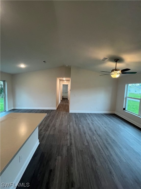 unfurnished living room with ceiling fan and dark wood-type flooring