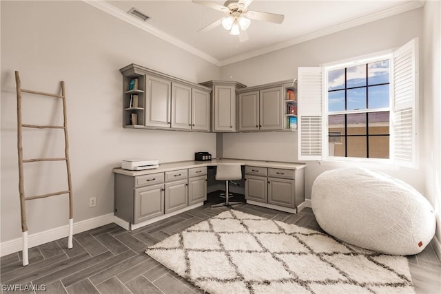 office featuring visible vents, ornamental molding, built in study area, ceiling fan, and baseboards