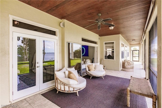 sunroom / solarium with french doors, a water view, wood ceiling, and a ceiling fan