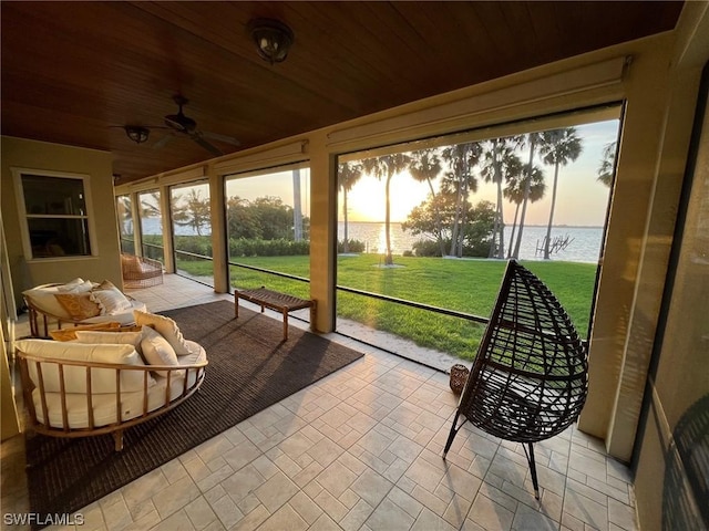 sunroom with a water view, wood ceiling, and a ceiling fan