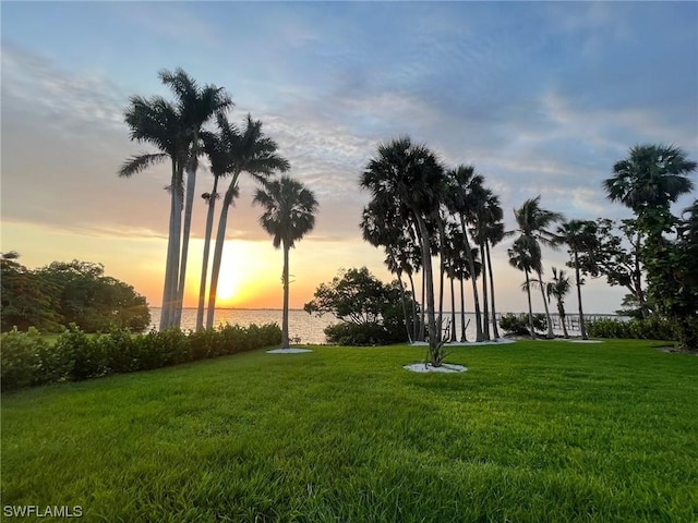 view of home's community featuring a water view and a lawn