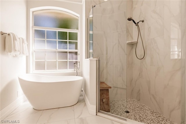 full bathroom featuring marble finish floor, a marble finish shower, and a freestanding bath