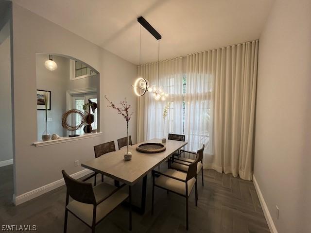 dining area featuring arched walkways and baseboards