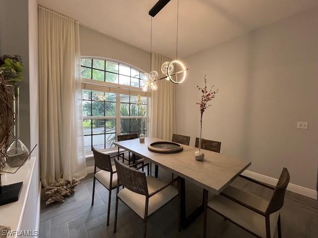 dining room featuring an inviting chandelier and baseboards