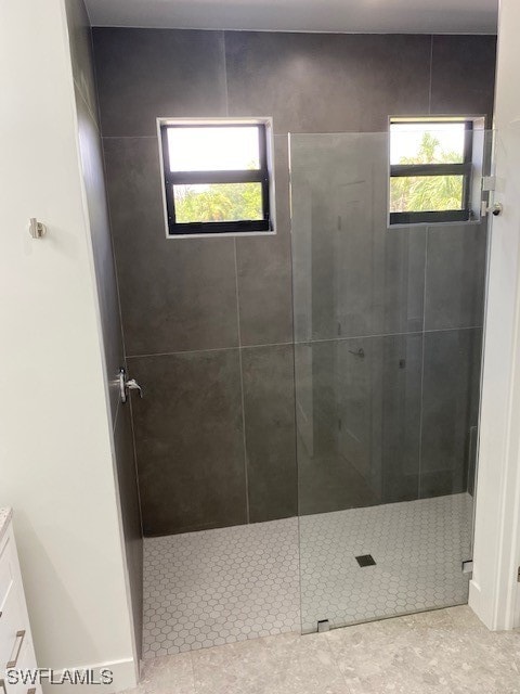 bathroom featuring tiled shower and vanity