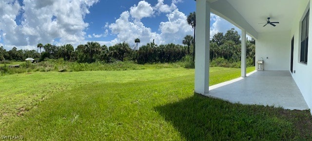 view of yard featuring ceiling fan and a patio