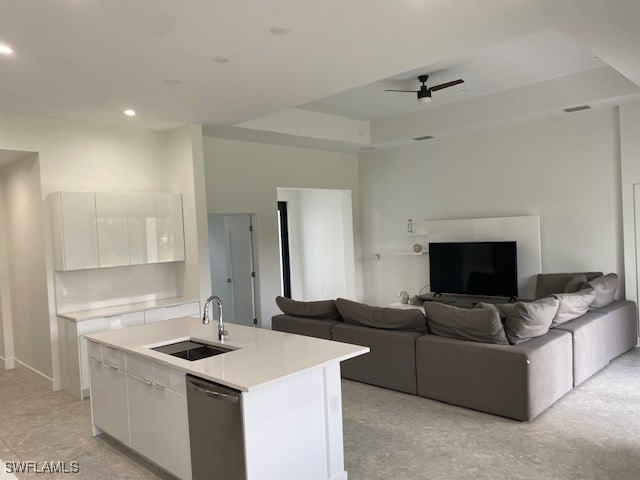 kitchen featuring white cabinets, sink, ceiling fan, a center island with sink, and stainless steel dishwasher