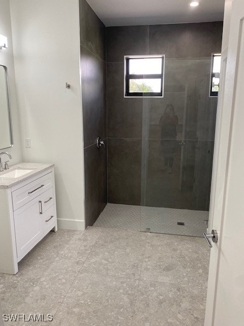 bathroom with vanity and a tile shower