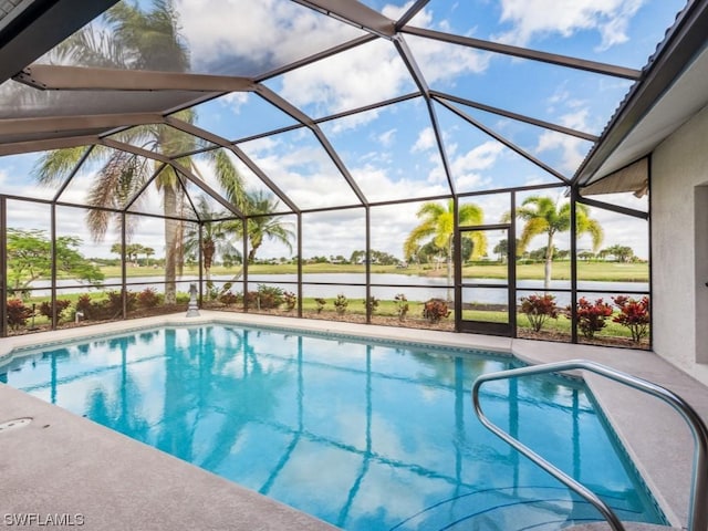 view of swimming pool featuring glass enclosure and a water view