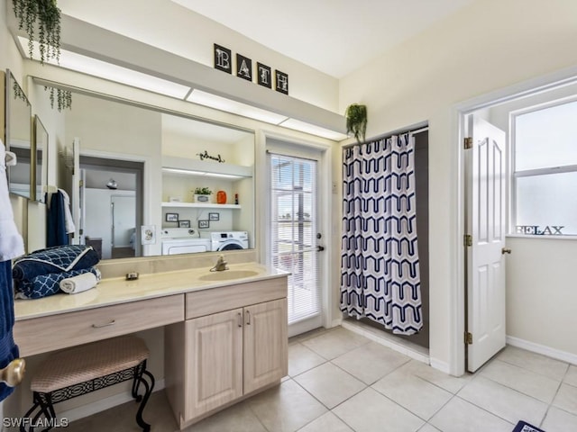bathroom featuring tile patterned flooring, vanity, and washing machine and dryer