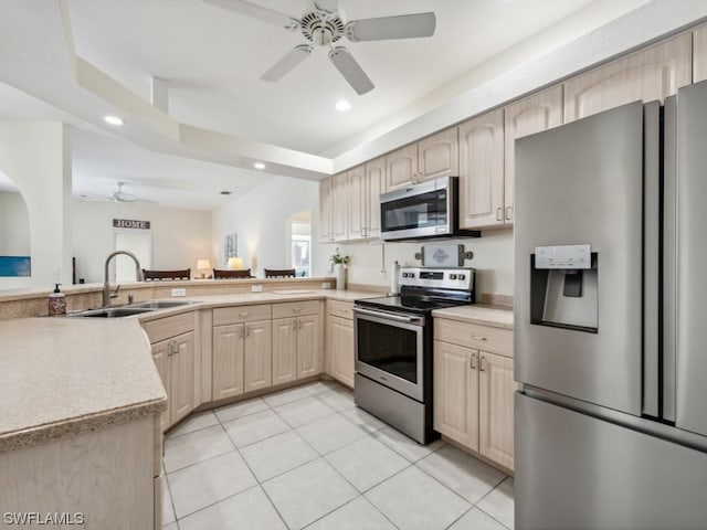 kitchen with sink, light tile patterned floors, light brown cabinets, kitchen peninsula, and stainless steel appliances