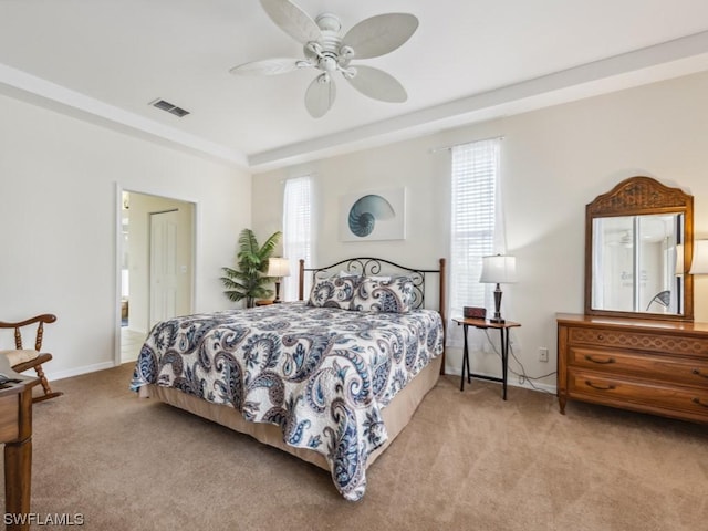 bedroom featuring light carpet, a raised ceiling, and ceiling fan