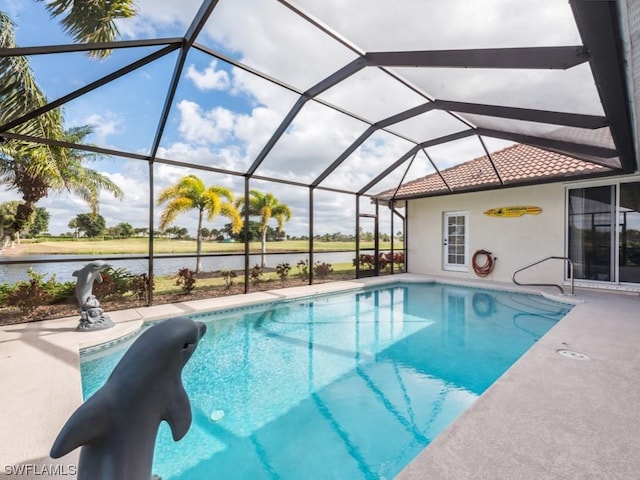 view of pool with a patio, glass enclosure, and a water view