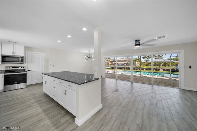 kitchen with white cabinetry, light hardwood / wood-style flooring, ceiling fan with notable chandelier, and stainless steel appliances