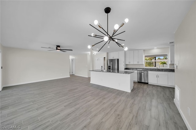 kitchen featuring pendant lighting, stainless steel appliances, ceiling fan with notable chandelier, white cabinetry, and light wood-type flooring