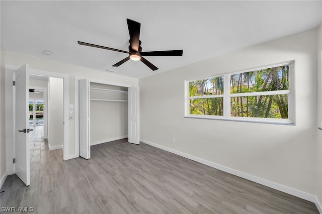 unfurnished bedroom featuring a closet, light hardwood / wood-style floors, and ceiling fan