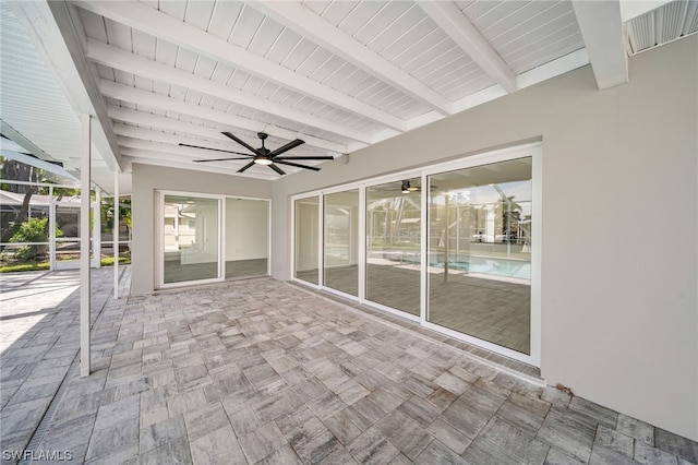 unfurnished sunroom featuring ceiling fan and beam ceiling