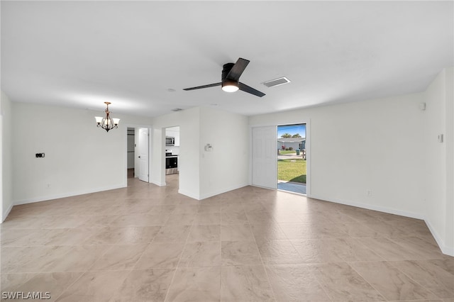 tiled empty room with ceiling fan with notable chandelier