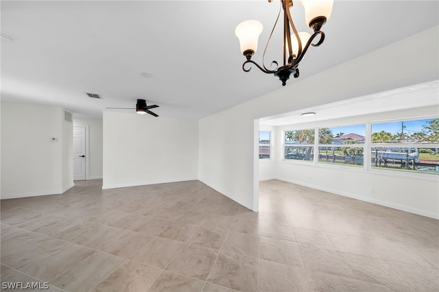 unfurnished room with ceiling fan with notable chandelier and light tile floors