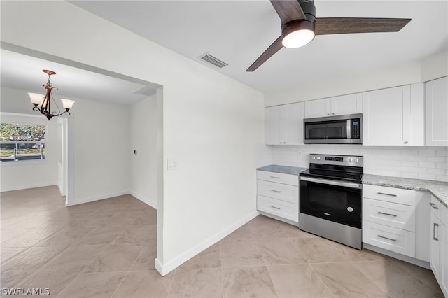 kitchen featuring appliances with stainless steel finishes, tasteful backsplash, ceiling fan with notable chandelier, and light tile flooring