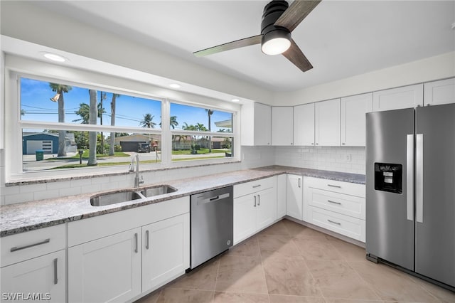 kitchen with tasteful backsplash, stainless steel appliances, white cabinetry, and sink