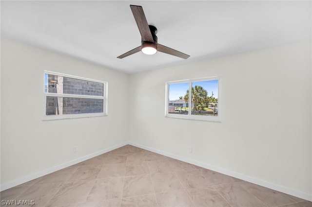 tiled empty room featuring ceiling fan