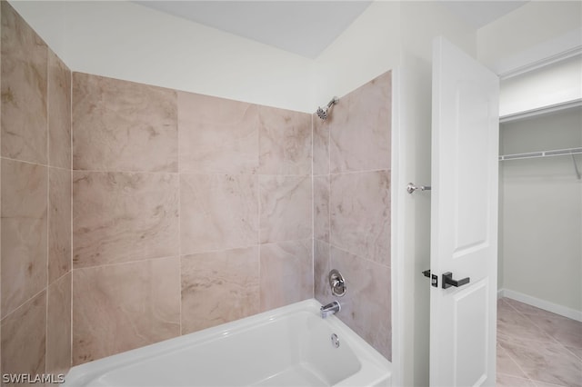 bathroom featuring tile flooring and tiled shower / bath