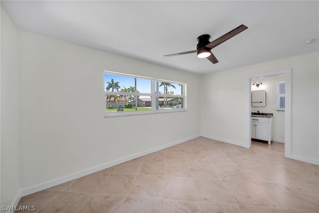 unfurnished bedroom with ceiling fan, light tile flooring, and ensuite bath