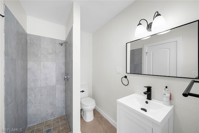 bathroom with large vanity, tile floors, toilet, and a tile shower