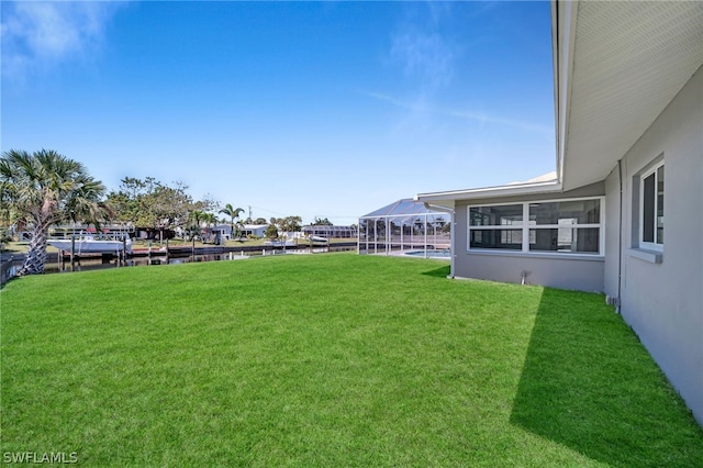 view of yard with a dock and glass enclosure