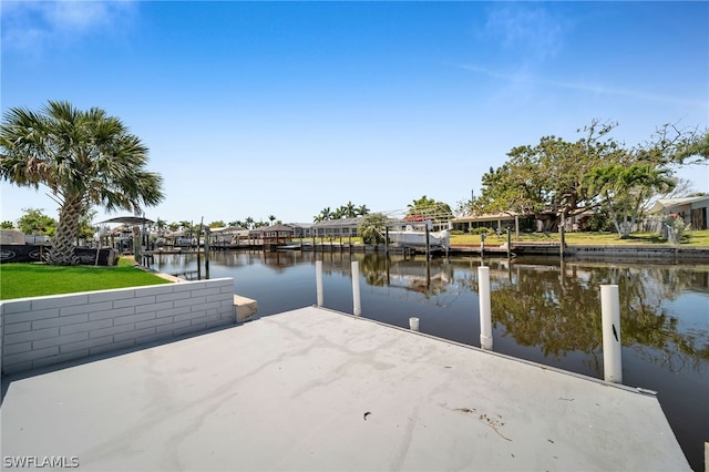 dock area with a water view and a lawn