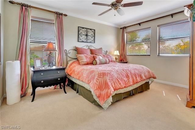 carpeted bedroom with ceiling fan and ornamental molding