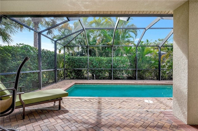 view of swimming pool with a patio and glass enclosure