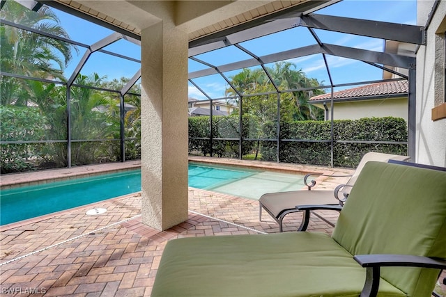 view of pool with a patio area and glass enclosure