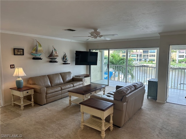 carpeted living room featuring ceiling fan, a healthy amount of sunlight, and crown molding