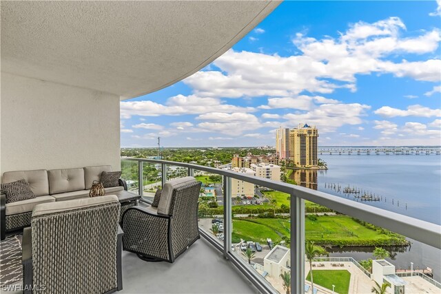 balcony with a water view and an outdoor living space