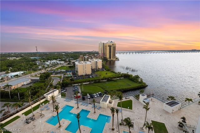 aerial view at dusk featuring a water view