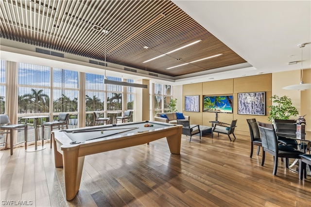 recreation room featuring hardwood / wood-style flooring, plenty of natural light, pool table, and a raised ceiling