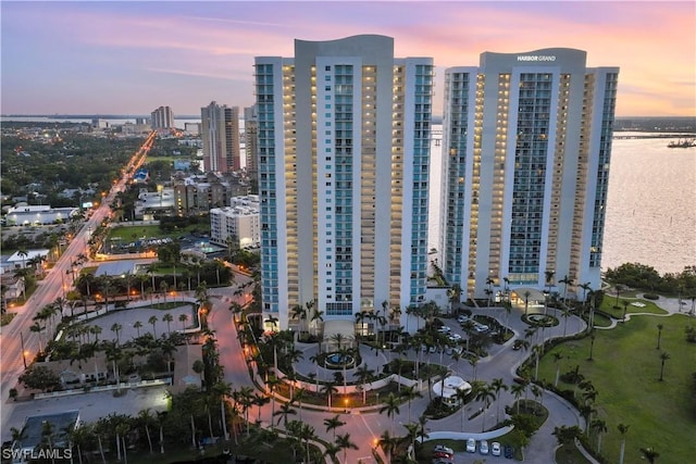 aerial view at dusk featuring a water view