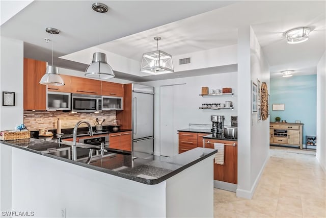 3000 Oasis Grand Blvd Unit 1507, Fort Myers, FL 33916 - kitchen featuring brown cabinetry, stainless steel appliances, a peninsula, tasteful backsplash, and visible vents