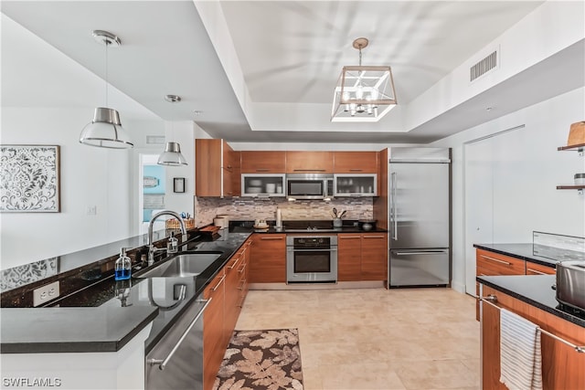 kitchen featuring stainless steel appliances, sink, decorative backsplash, and decorative light fixtures